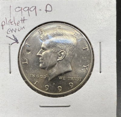 1999 Kennedy half dollar clipped planchet error showing curved section of missing metal at the rim